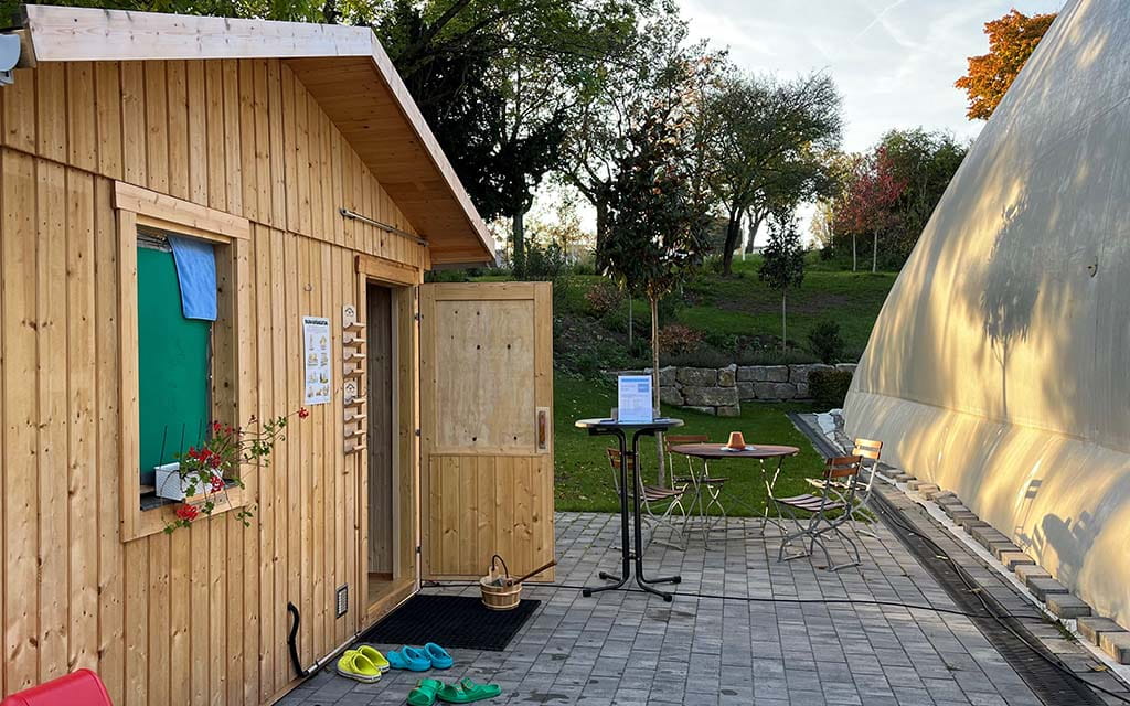 Außen-Biosauna aus Holz neben der Traglufthalle des Taubertsbergbads